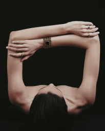 Close-up portrait of a model showcasing Chanel luxury jewelry and watch against a dark background