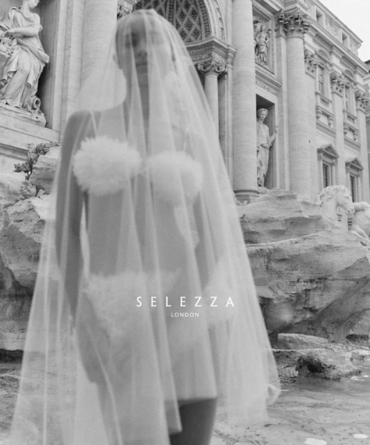 Woman in lingerie and veil in front of the Trevi Fountain in Rome. Fashion style advertisement. Monochrome black and white photo.