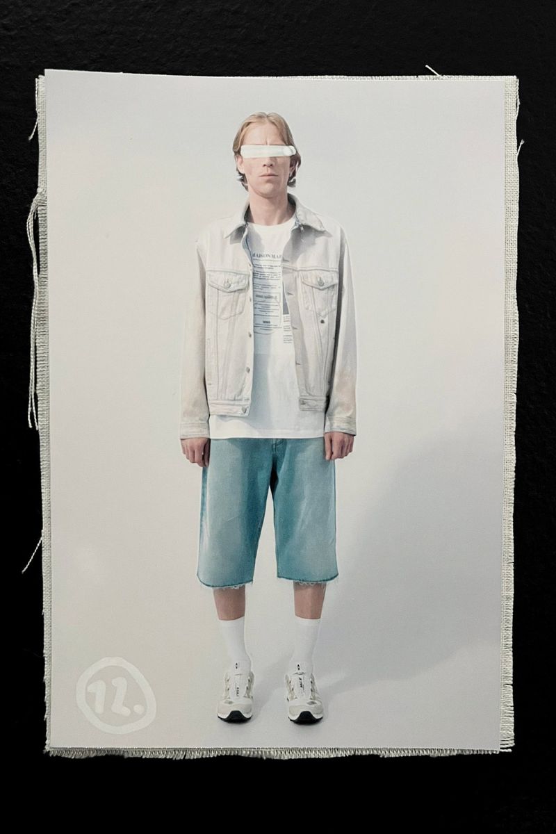 Full body shot of a slender adult male with light skin wearing a denim jacket, shorts, white t-shirt, socks, and sneakers on a white background.