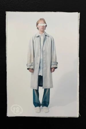 Fashion shot of a person wearing a long coat and jeans against a white background, captured in a studio setting with neutral colors.
