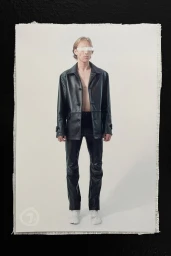 Model wearing a black leather jacket and pants with a white band covering his eyes against a white background.