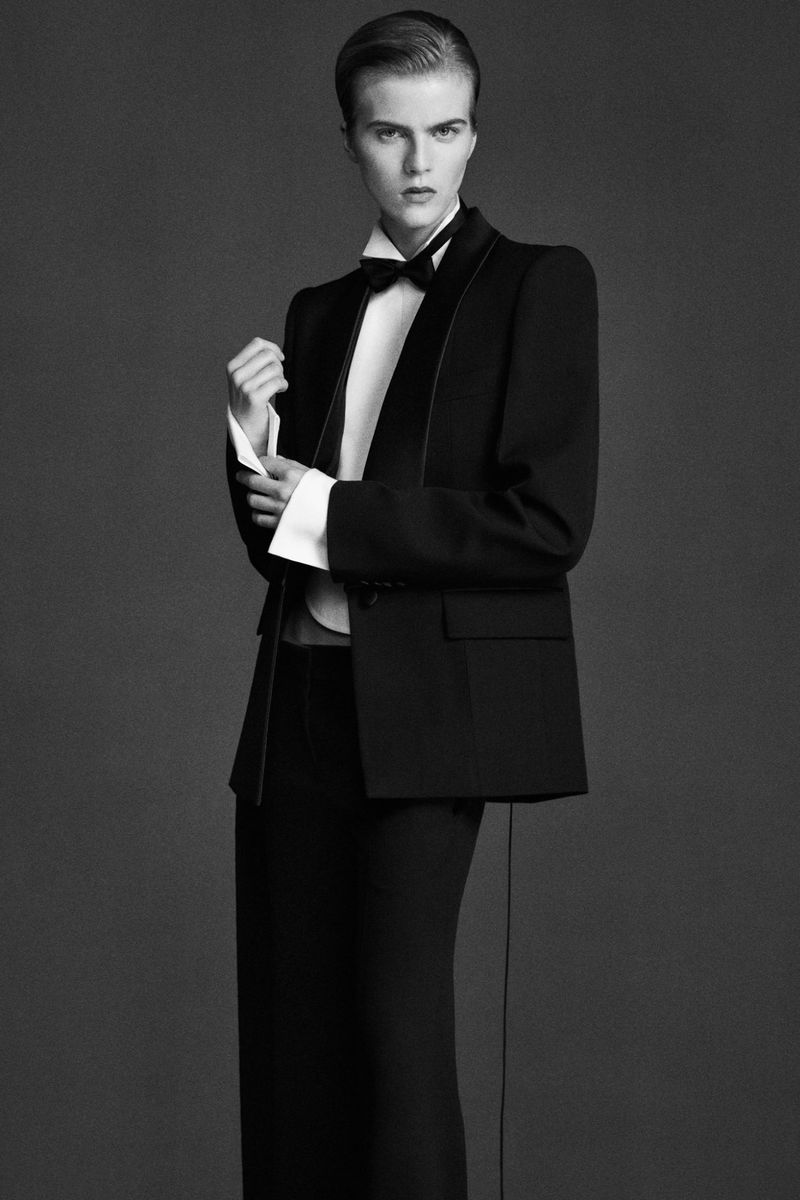 Black-and-white fashion shot of a model in a classic tuxedo with a bow tie, showcasing elegant tailoring and a timeless style.