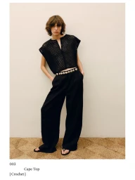 Model wearing a black patterned crochet cape top and wide trousers against a neutral background for Massimo Dutti