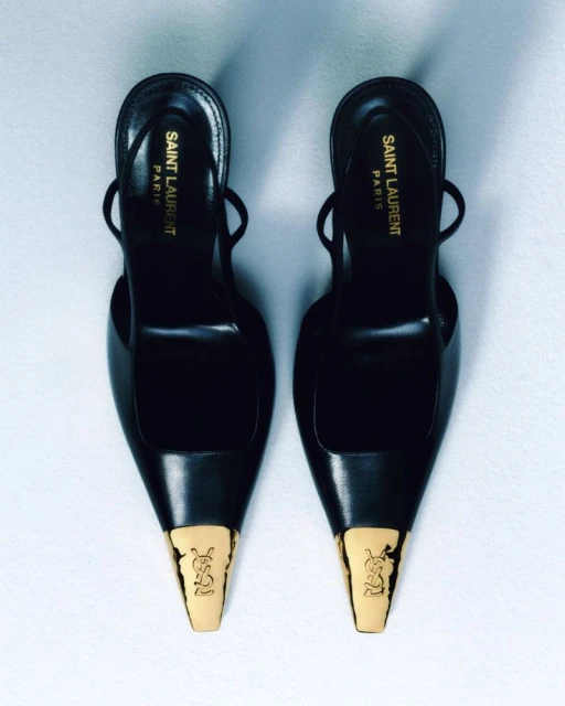 Elegant black slingback heels by Saint Laurent, featuring a pointed toe with gold accents and a YSL logo on a clean background.