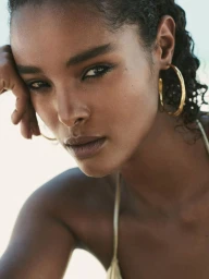 Close-up portrait of model Malika Louback wearing gold hoop earrings for Massimo Dutti Holbox, photographed by Ed Martin.