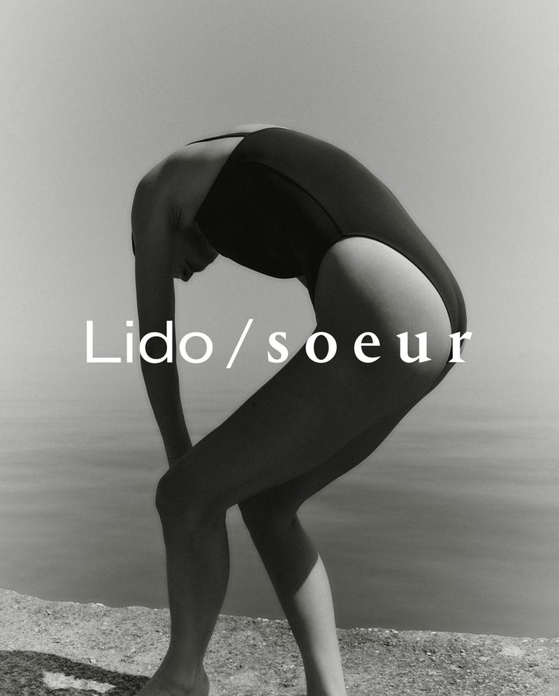 A slender woman in a black swimsuit bends backward on a concrete ledge overlooking calm water. The text 'Lido/soeur' is superimposed.