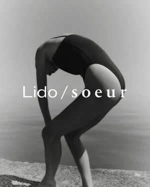 Model in a black one-piece swimsuit arching her body against an outdoor water and sky background with overlaid text