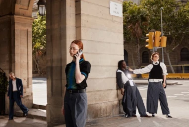 Four models posing in an urban street scene with stone archways and traffic lights for the Armand Basi x Per Gotesson 2024 collection.