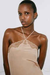 Model wearing nude lace halter top against a white wall background for Chlo Fall 24 lookbook