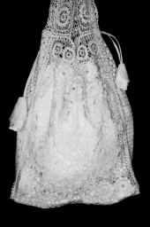 White crochet lace drawstring pouch bag featuring floral openwork motifs against a solid black background.
