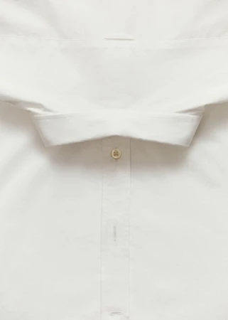 Close-up of a white dress shirt with a visible button and collar, showcasing texture and garment construction.