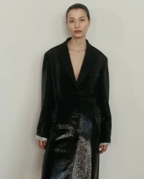 Model wearing a black blazer and dark textured skirt against a neutral background for Veronica De Piante