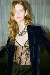 Model Apolline Rocco Fohrer wearing a blue velvet blazer, black sheer lace corset, and statement necklace for Zara Ancora.