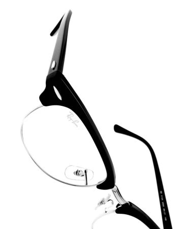 Close-up of Ray-Ban glasses with black frames and clear lenses, showcasing a modern design against a white background.