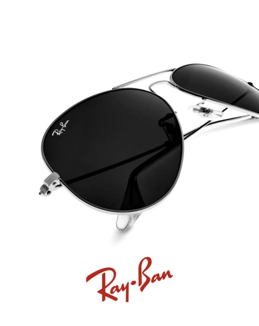 Close-up of silver Ray-Ban aviator sunglasses with black lenses on a white background, showcasing the brand logo and design.