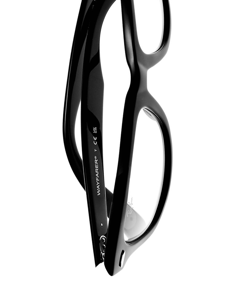 Close-up studio shot of a pair of glossy black Wayfarer eyeglasses against a clean white backdrop, highlighting the glasses' design.