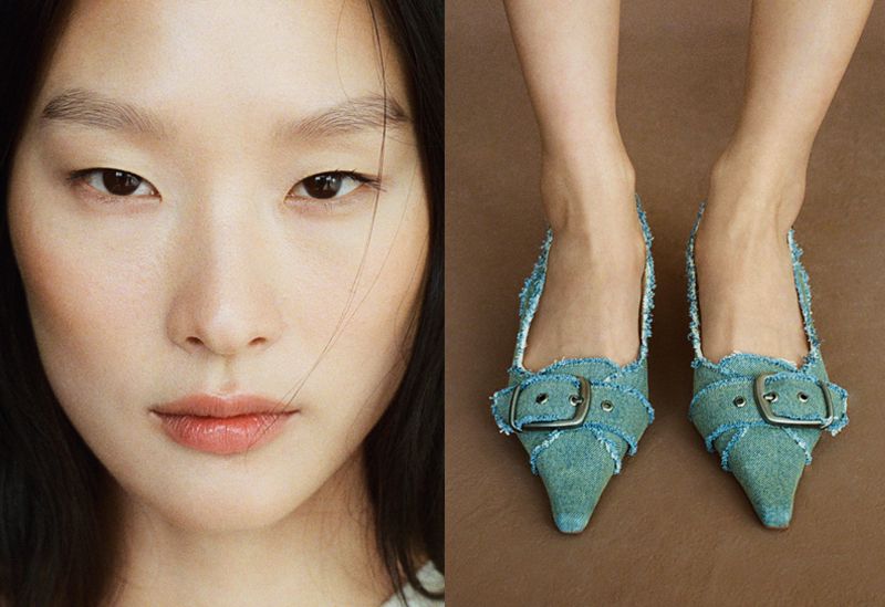 Close-up of a stylish adult woman with fair skin and dark hair, alongside a pair of denim heeled shoes with metallic buckles on a brown background.