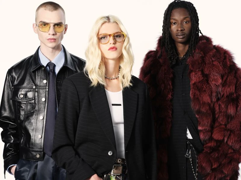 Three diverse fashion models—male and female—wearing glasses, dark jackets, and fashionable clothing against a plain white backdrop.