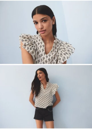 Portrait of a woman in a patterned top and black shorts against a light blue background, fashion photography, studio shot.