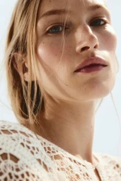 Close up portrait of model Liz Kennedy wearing a white crochet top for H and M Edition Collection Petals