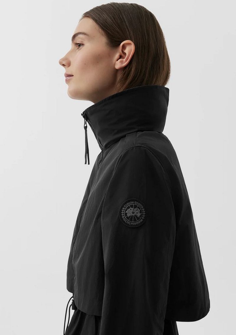Profile of a young adult woman wearing a black Canada Goose hooded jacket against a neutral background in a studio lighting setting.