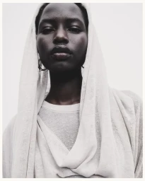 Model Nyaduola Gabriel draped in a light off-white knit headscarf for Massimo Dutti S/S 24, photographed by Sara Morán.