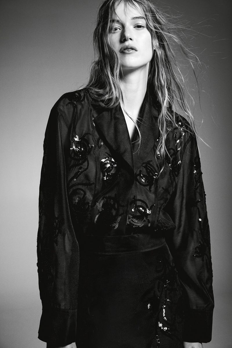 Model in a dark embroidered blouse against a grey seamless background for H&M autumn winter campaign