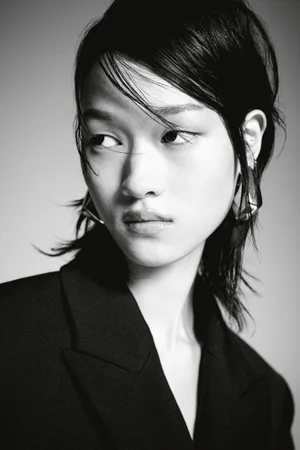 Close-up portrait of model Chloe Oh wearing a black blazer against a grey backdrop for H&M A/W 2024 campaign