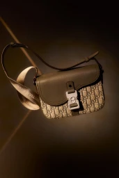 Dior Men olive leather and canvas saddle bag with Christian Dior strap against a dark background