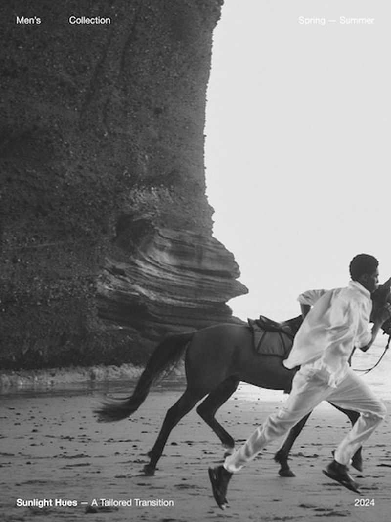 A man in white running with a horse on a beach, monochromatic style, with rocky cliffs and promotional text for a men's collection.