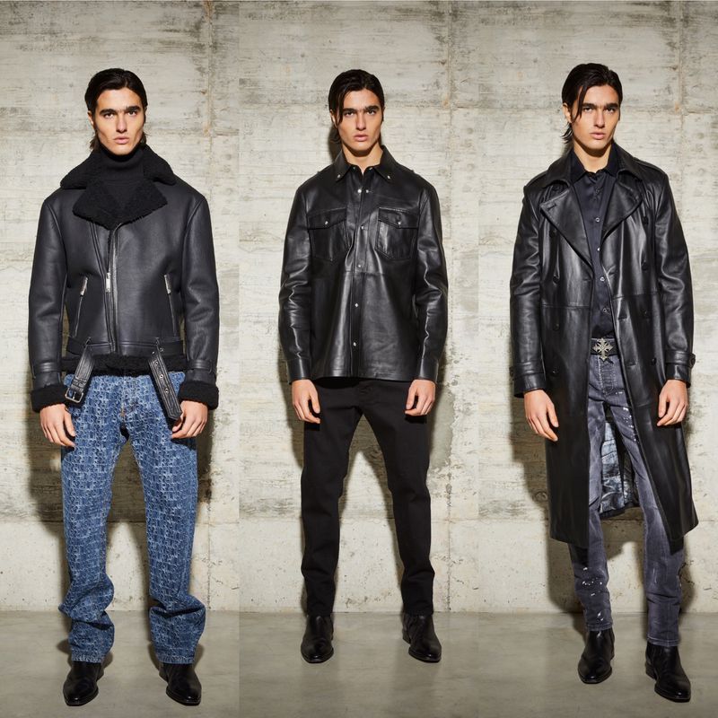Three adult males present different fashion outfits against a neutral concrete backdrop in a studio shot, displaying leather jackets and coats.