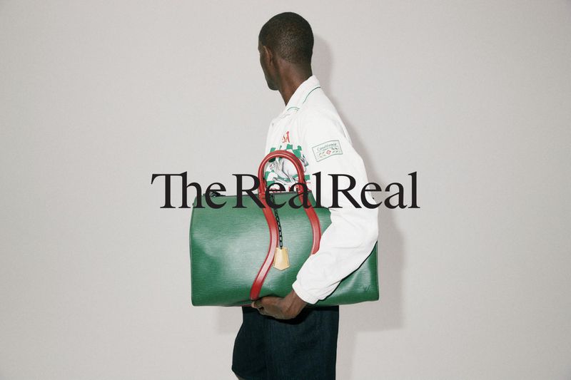 A person is holding a green Louis Vuitton duffle bag against a neutral backdrop, featuring the 'The RealReal' logo overlaid on the image.
