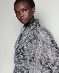 Model wearing a textured grey fringed jacket against a pale neutral background for Scanlan Theodore