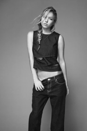 Model Lila Moss wearing dark denim sleeveless top and trousers in a studio portrait by David Sims for Zara.