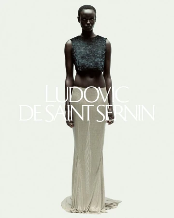 Elegant Black model poses in a green sequined crop top and a shimmering gold skirt in a fashion photo against a white backdrop.