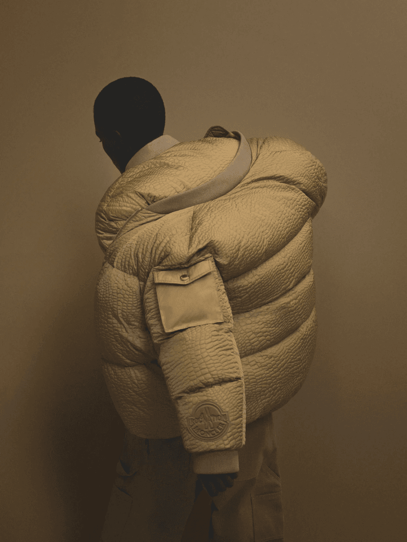 Fashion shot of a person wearing an oversized, textured puffer jacket in a studio setting, creating a modern and stylish look.