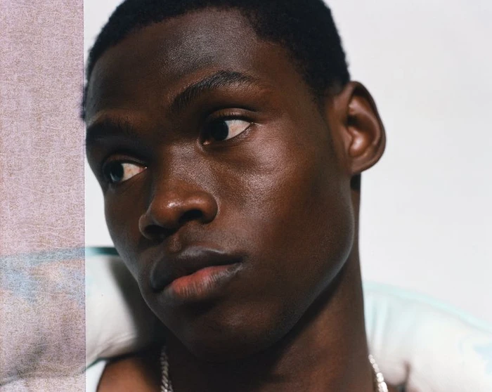Close-up portrait of a Black man looking aside with a silver chain necklace for Zara Miami Capsule Collection