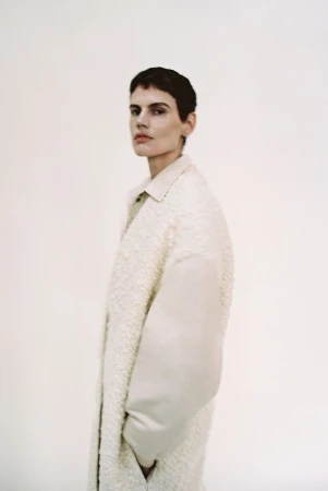 Model Saskia de Brauw in an off-white textured coat against a plain white studio background for Gabriele Colangelo