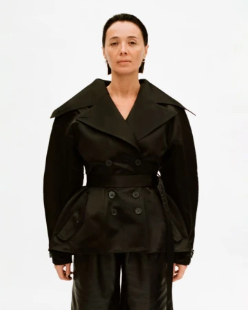 Model wearing a structured black double-breasted jacket against a clean white background for Situationist lookbook