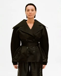 Model wearing a structured black double-breasted jacket against a clean white background for Situationist lookbook