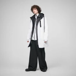 Model wearing white puffer jacket, layered dark shirt, and wide black trousers against a neutral light grey background.