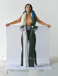Model Paloma Elsesser holding a printed poster featuring her portrait for the Present Space Print Six Covers project