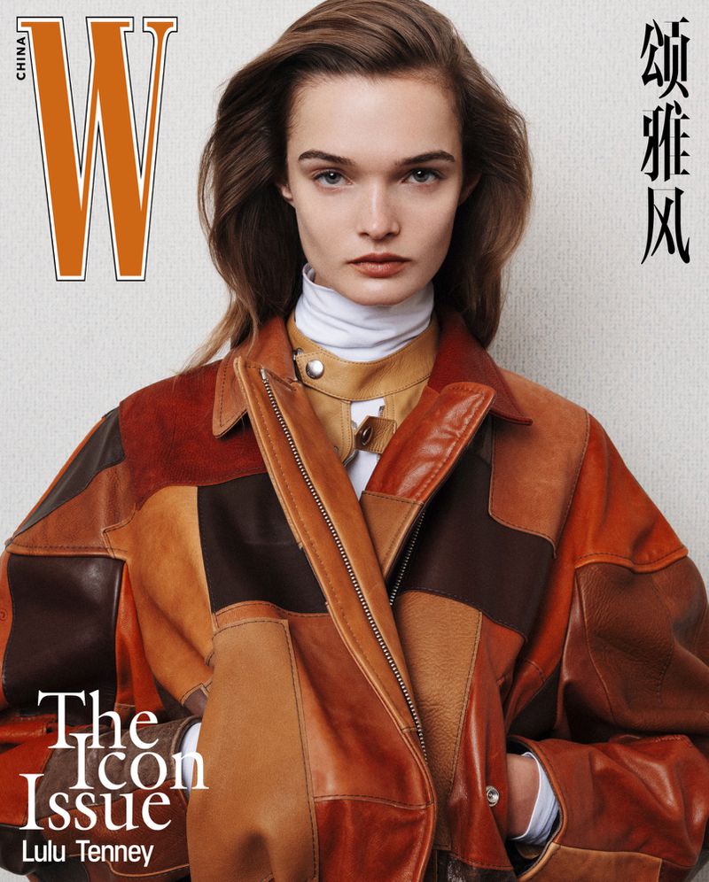 Magazine cover featuring a woman with brown hair, wearing a multicolored leather jacket, looking directly at the camera with a neutral expression.