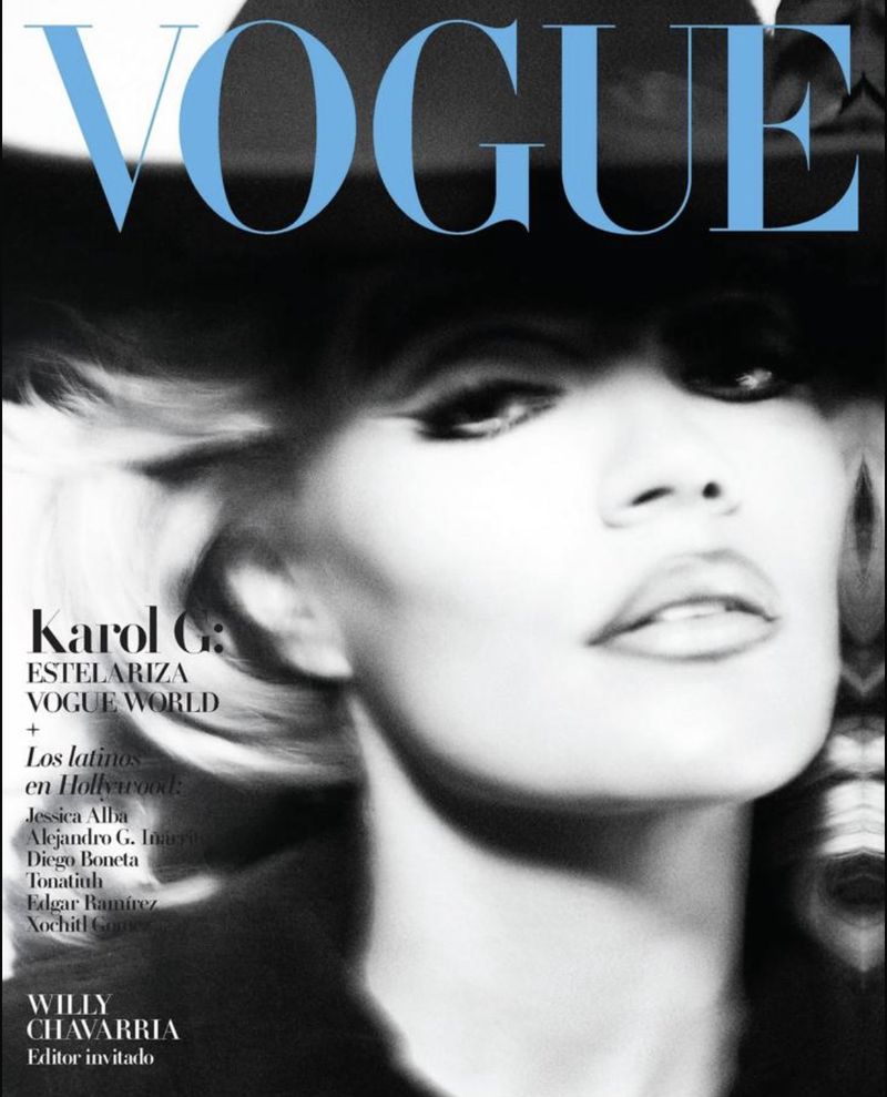 Vogue cover featuring Karol G. in a black and white portrait, showcasing a hat and makeup, against a light blue 'Vogue' masthead.