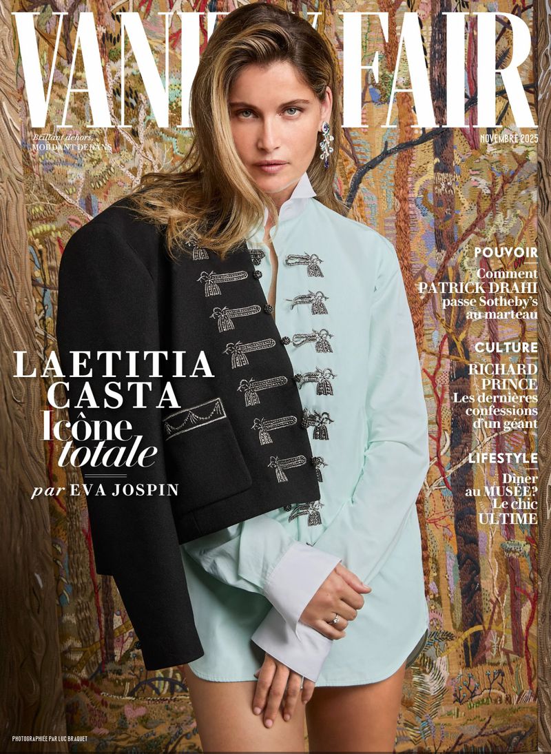 Magazine cover featuring Laetitia Casta in a light blue shirt with a jacket draped over her shoulder against a tapestry background.