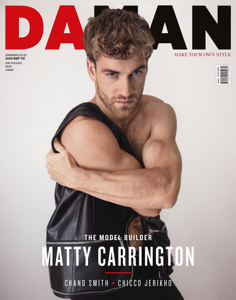 Magazine cover featuring a muscular man in a black leather vest, arms crossed, with DA MAN logo and text overlaid on a white background.