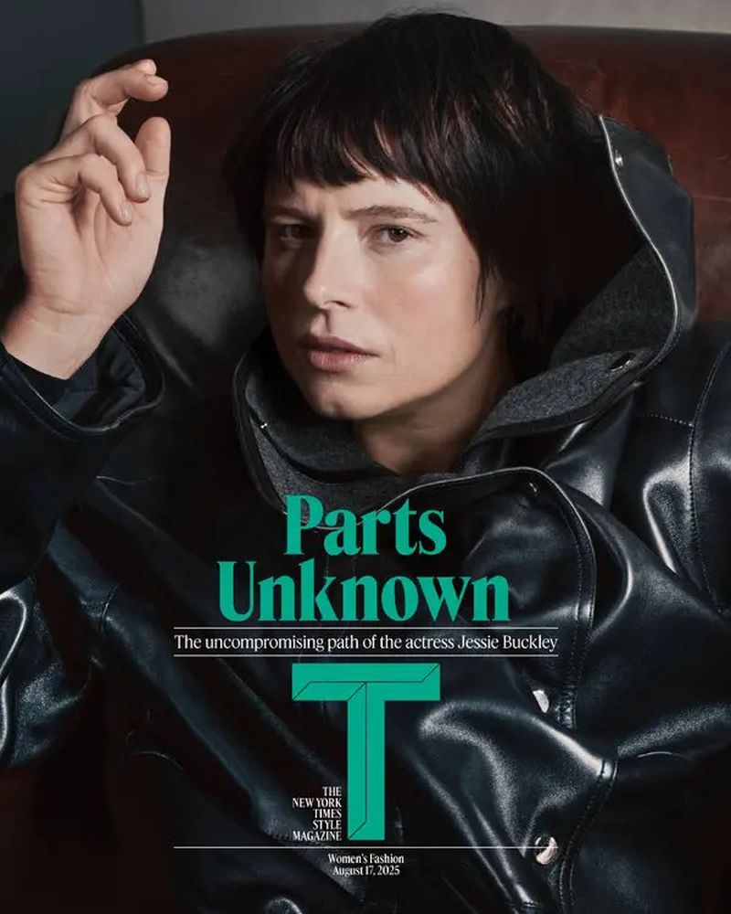 Close-up of a woman with short dark hair wearing a black hooded jacket, posing in a leather chair, as seen on a magazine cover.