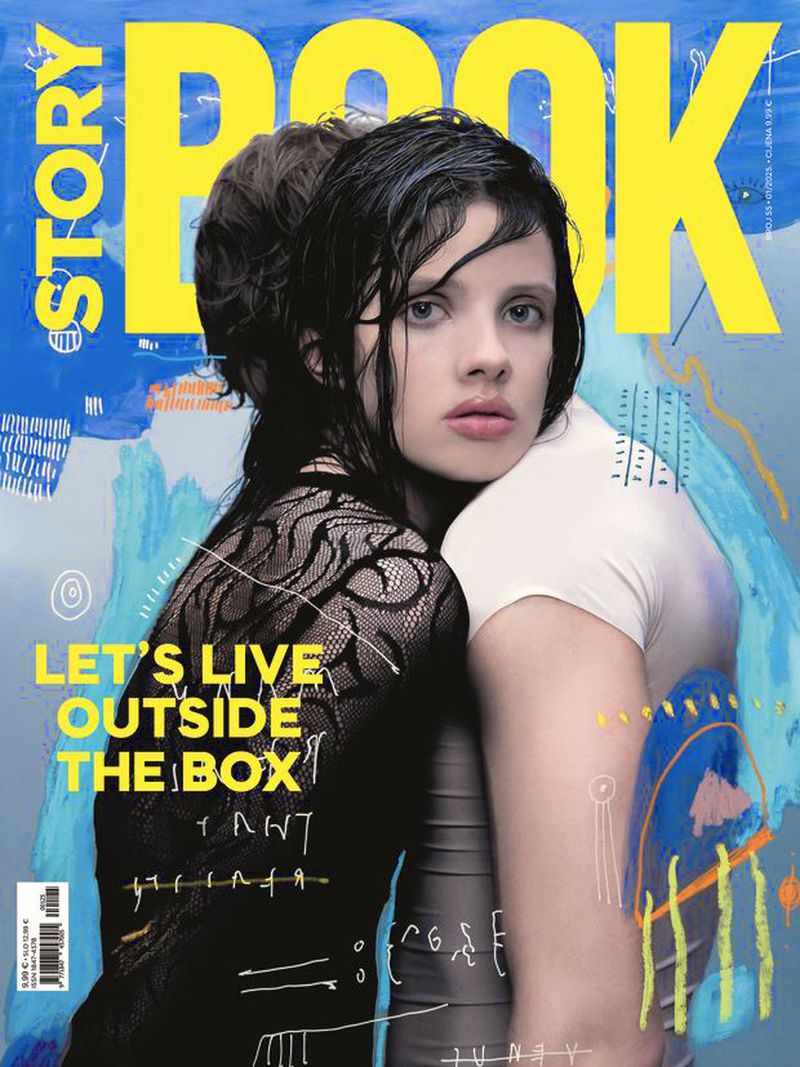 Magazine cover featuring two women, one in black lace and the other in white, against a backdrop of blue and yellow abstract art.
