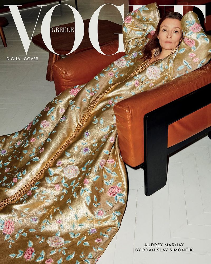 Vogue Greece digital cover featuring Audrey Marnay in an orange leather chair wearing a long, gold, floral-patterned gown.