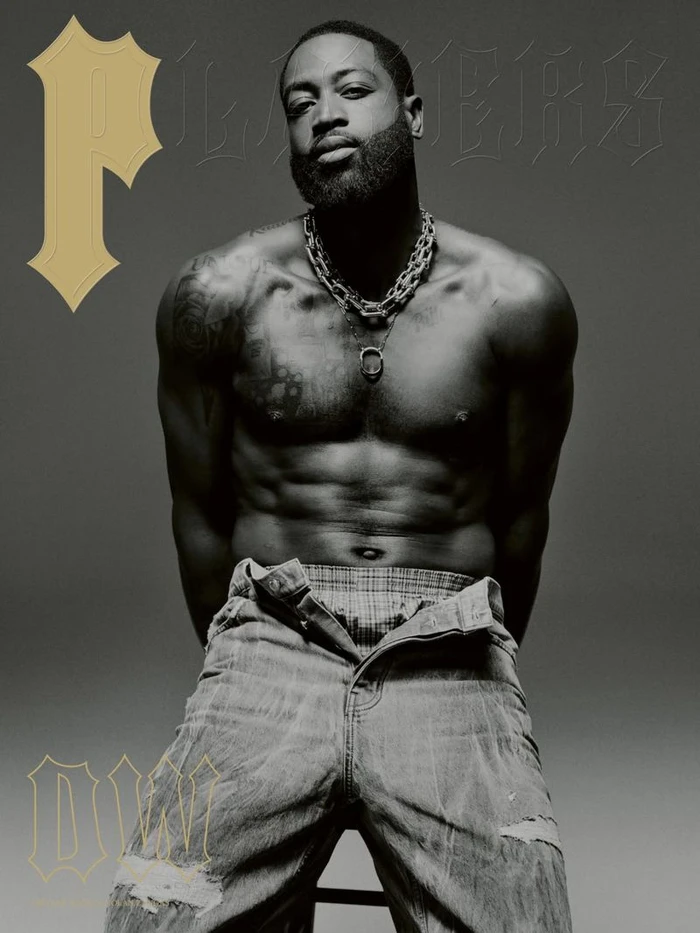 Black and white portrait of shirtless Dwyane Wade wearing a thick chain necklace and unbuttoned denim jeans for Players magazine cover.